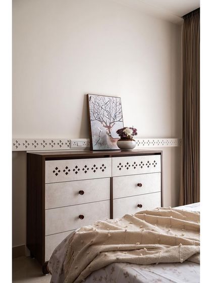 A custom chest of drawers in the parents' bedroom continues the theme of traditional detailing, with intricate cutouts on the drawer fronts that match the pattern on the wardrobe.