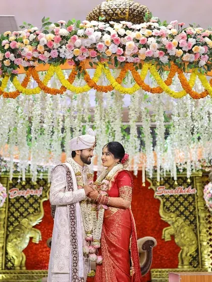 A grand portrait of the couple under a magnificent floral mandap. We ensure we capture both the intimate emotions and the grand scale of your wedding decor and setup.