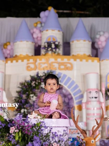 Little princess Varnnika sitting majestically on her throne in front of her fairytale castle.