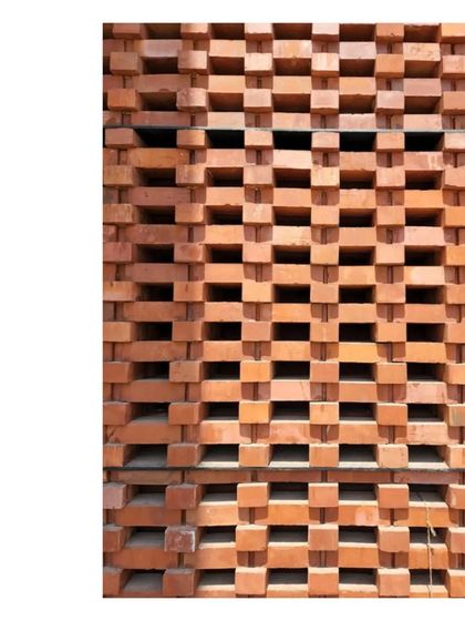 A detail of the 'Ishtika' brick jaali wall. The perforated screen allows the building to breathe while creating beautiful patterns of light and shadow.