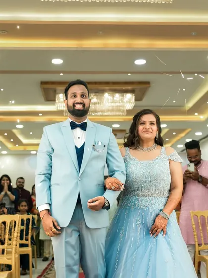 The couple makes their grand entrance at their engagement party, walking down the aisle as guests look on.