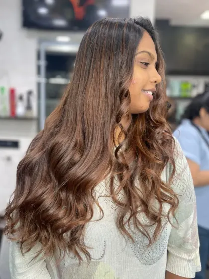 Beautifully styled long hair with warm brown tones and soft curls, creating a rich and luxurious look.