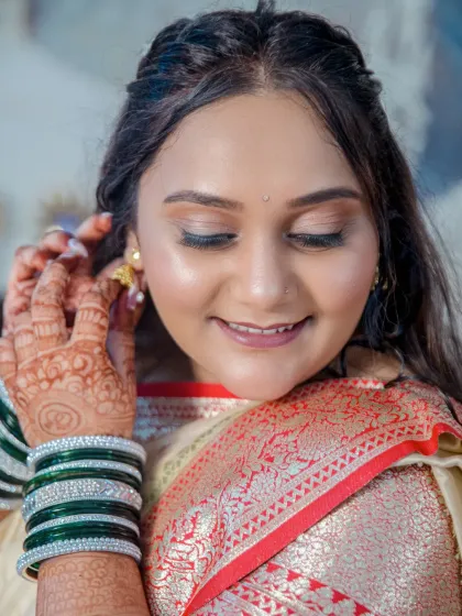 A close-up of the bride-to-be adjusting her earring, a lovely candid moment that highlights her beautiful jewelry and serene smile.