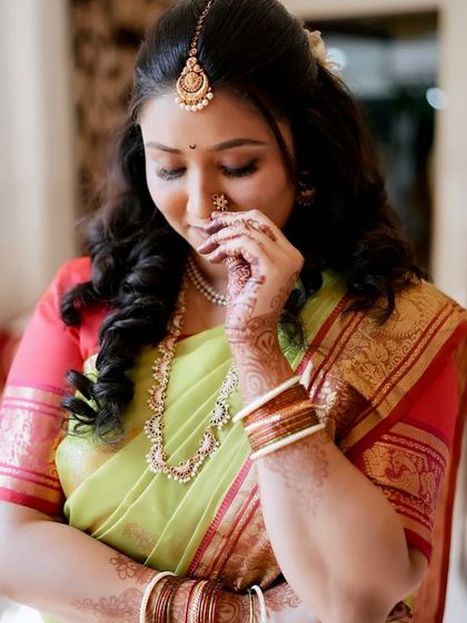 A shy, beautiful moment captured. The makeup enhances her features while maintaining a natural and elegant feel.