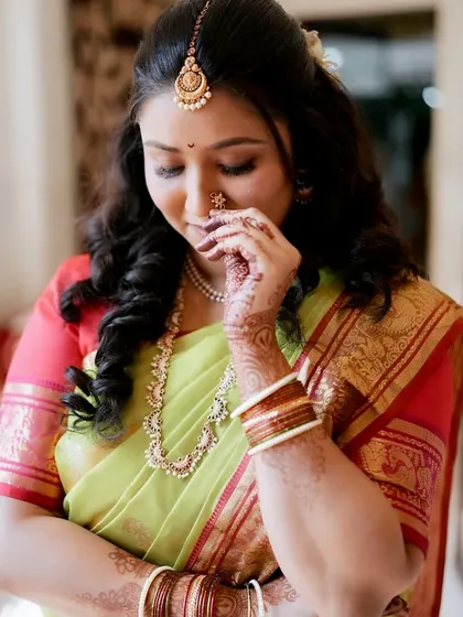 A shy, beautiful moment captured. The makeup enhances her features while maintaining a natural and elegant feel.