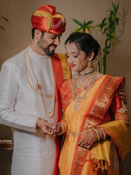 A close-up of the couple holding hands, focusing on their gentle interaction and the intricate details of their wedding attire.