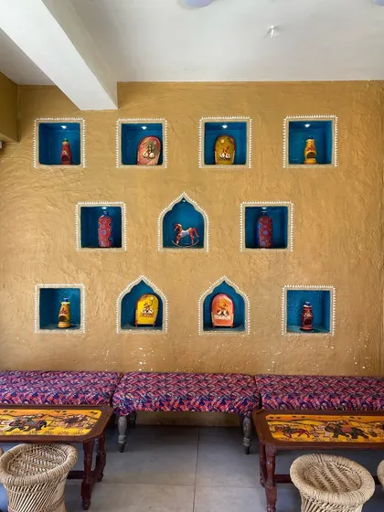 For this project, I brought a traditional Indian vibe to a modern eatery. The textured mud wall is highlighted by hand-painted niches, each telling a small story and creating a warm, inviting atmosphere for guests.