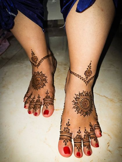 A minimal and elegant design for the feet, featuring a central mandala and a delicate anklet pattern.