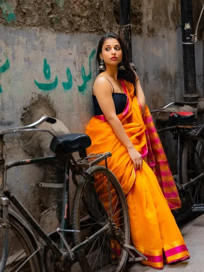 My work isn't limited to Mumbai. Here in the narrow alleys of Delhi, we found this amazing contrast of a vibrant yellow saree against the old, textured walls and a rustic bicycle, telling a unique city story.