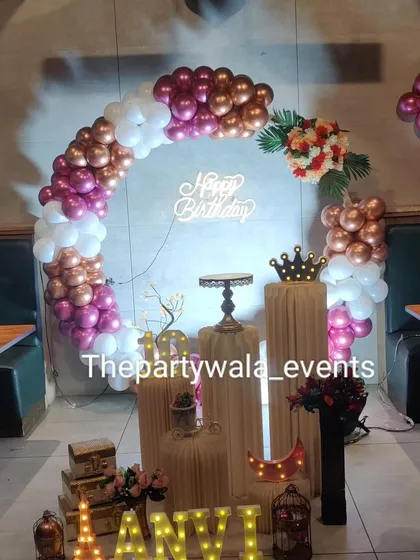 A glamorous ring decoration with magenta, rose gold, and white balloons. The setup is perfect for a milestone birthday or an elegant party.