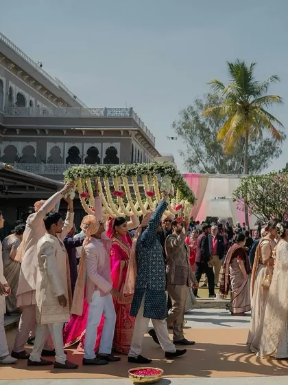 The full view of the bridal entry at a palace wedding in Udaipur, showcasing the scale and energy of the moment.