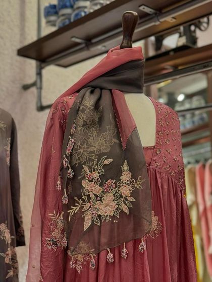 A close-up of a beautiful organza dupatta with floral embroidery, draped over a dusty pink Anarkali from Kora's new collection.