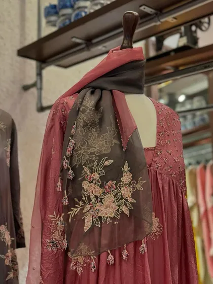 A close-up of another Kora piece, this time a dusty pink anarkali with a beautifully embroidered organza scarf draped around the neck.