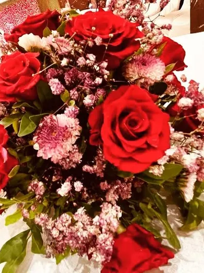 A classic table centerpiece featuring red roses and delicate filler flowers. We ensure that even the smallest details, like table arrangements, are beautifully crafted and contribute to the overall event design.