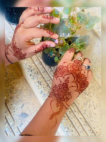 A candid shot of a client admiring her fresh, delicate henna stain.