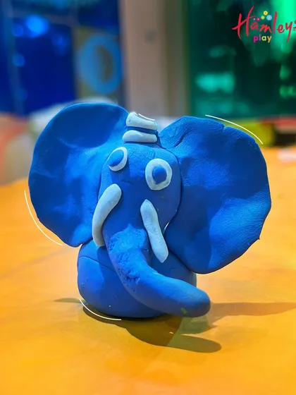 A close-up of a unique blue clay elephant, showcasing the creativity that our Ganpati workshops inspire. Every idol is different and special!