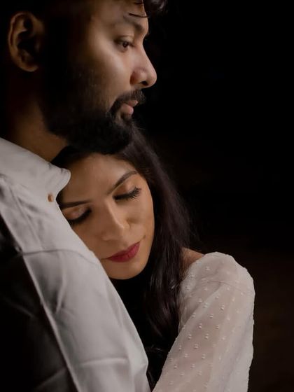 A dramatic, low-light shot. The makeup features a bold red lip that stands out beautifully in the dark, creating a very romantic mood.