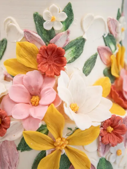 A close-up look at the heart of my craft: handcrafted sugar flowers. Each petal on this floral wedding cake is individually shaped and painted to create a lifelike garden of colorful blooms, turning a simple cake into a piece of botanical art.