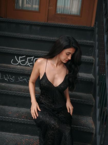 An urban-chic shot of Disha on the steps in New York. Her hair and makeup look effortlessly cool, perfect for the city's vibe during Fashion Week.