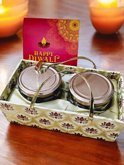 This simple and elegant gift set includes two glass jars filled with treats, presented in a beautiful brocade basket with a matching Diwali card. It's a perfect budget-friendly option that doesn't compromise on style.