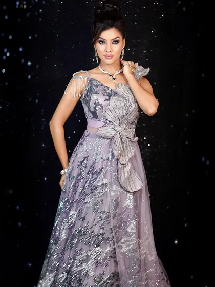 Serving looks that slay all day. A full-length shot of a model in a stunning silver and lavender gown.