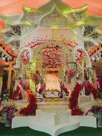 This grand, multi-tiered mandap was a masterpiece of design. The intricate white structure, adorned with arches of red florals, created a regal and opulent atmosphere for a truly magnificent wedding ceremony.