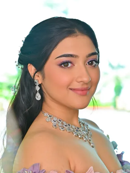 A close-up of this whimsical, carnival-inspired makeup. The shimmery purple eyeshadow and flawless skin create a look that is pure enchantment.