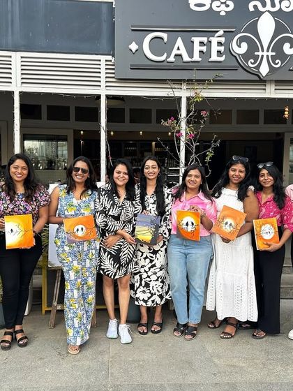 A great group photo outside the cafe venue, with everyone holding up their finished paintings.