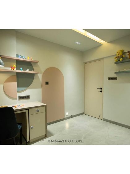 A minimalist and playful toddler's room. The geometric color blocking and open shelving for toys create a space that is stimulating but not cluttered.