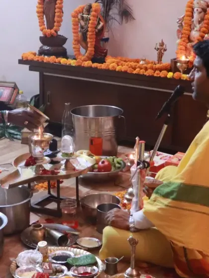 A close-up of the sacred offerings and rituals being performed during a puja. Every element, from the flowers to the flame, holds symbolic meaning in our tradition.
