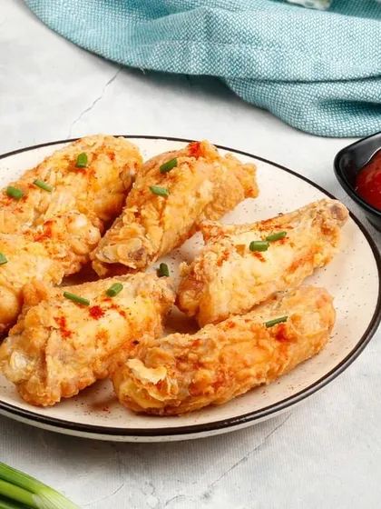 Our crispy Fried Chicken Wings, garnished with a sprinkle of chilli flakes and chives for a little extra flavour.