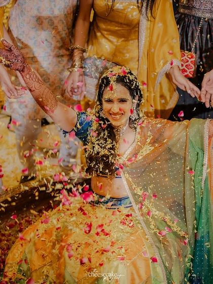 The bride with her arms outstretched, embracing the shower of flowers from her loved ones.
