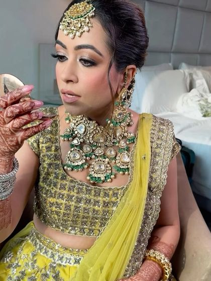 A moment of admiration. The client checks out her makeup, which features a beautiful smokey eye and flawless skin.