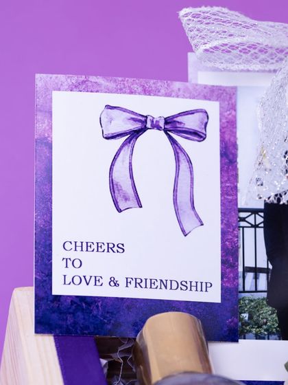 A detail shot of the custom card in the bridal hamper, reading "Cheers to Love & Friendship." It's these small, thoughtful details that make a gift memorable.