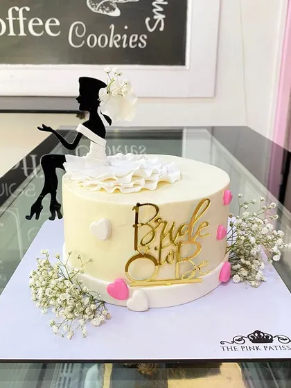 A chic "Bride to Be" cake with a silhouette topper, perfect for a bachelorette party or bridal shower.