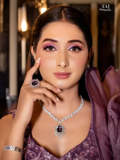A stunning bridal portrait focusing on her magnificent amethyst and diamond jewelry set. Her direct gaze is confident and captivating.