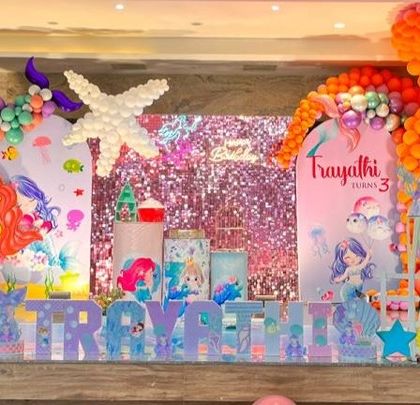 An elaborate under the sea mermaid party, featuring a massive octopus balloon sculpture, a shimmer wall, and multiple character cutouts.