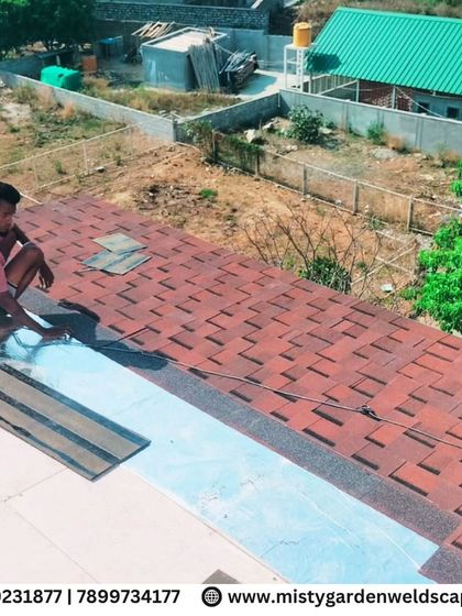 A worker carefully places the final shingles on the roof. This meticulous process ensures a perfect finish and long-lasting durability for the pergola.