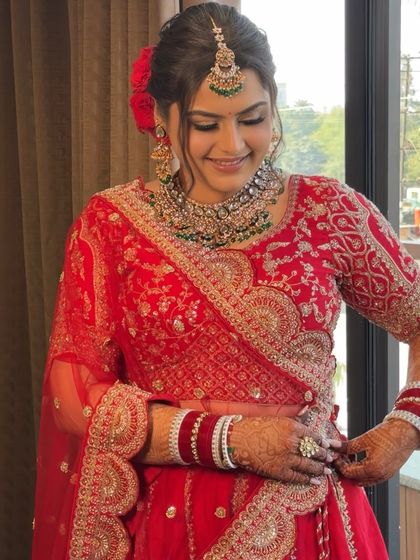 A beautiful, happy moment with my bride Jagriti. Her classic red lehenga is paired with a soft glam makeup look, featuring a subtle smokey eye and a flawless, dewy base that looks incredible in natural light.