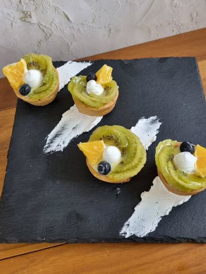 Our Fruit Symphony tart is a vibrant chorus of fresh kiwi, orange, and berries atop a creamy custard base. It's a refreshing and beautiful dessert.