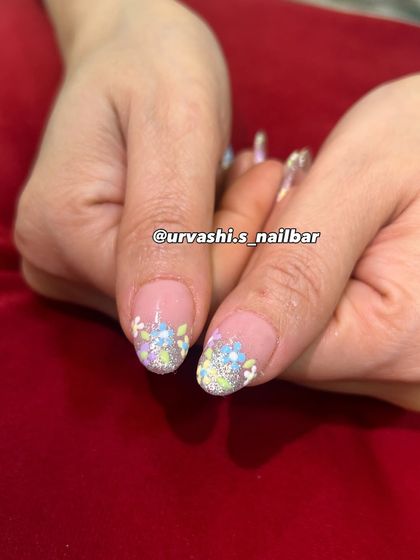 A dreamy, feminine design with delicate 3D-style pastel blossoms. The flowers are set against a shimmery, soft gradient base, giving the manicure a gentle yet luxurious feel perfect for spring.