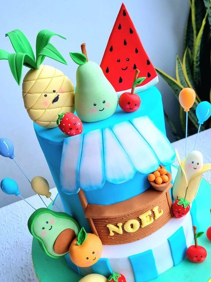 A close-up of the "tutti frutti" cake, showing the cute faces on the fondant fruits.