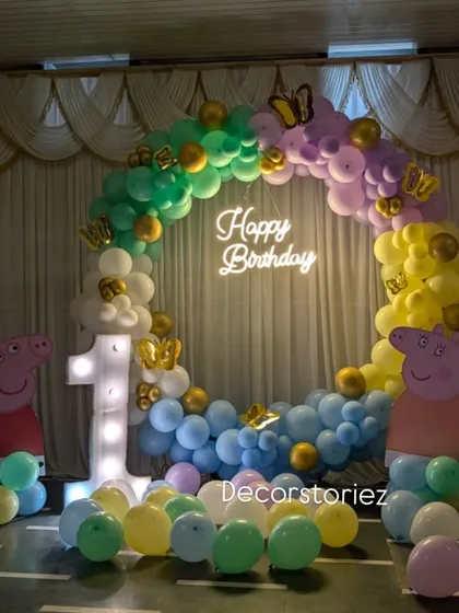A nighttime view of the Peppa Pig ring decoration, showing how the 'Happy Birthday' neon sign beautifully illuminates the entire setup.