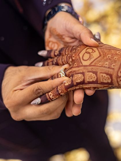 The moment the ring is placed on her finger, with her beautifully stained mehendi as the perfect backdrop.