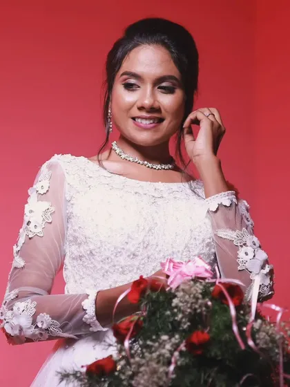 A smiling bride holding her bouquet. Her makeup is soft and natural, perfect for her Christian wedding day.