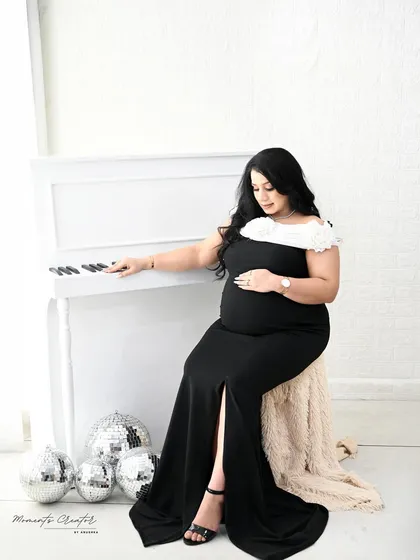 A graceful seated pose by the piano. This shot captures a quiet moment of reflection, with the soft lighting adding to the serene atmosphere.