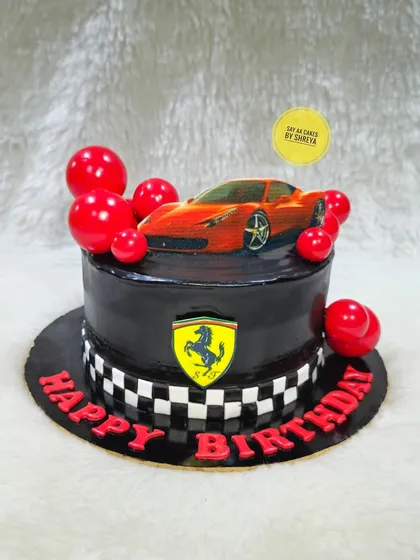 A sleek and stylish Ferrari cake for a car enthusiast. The black fondant, checkered flag detail, and iconic Ferrari shield create a design that's all about speed and luxury.