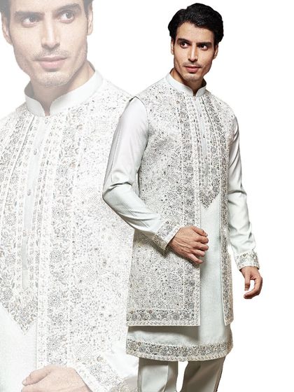 The essence of royal charm. This heavily embroidered sherwani in a subtle off-white is a masterpiece of our craftsmanship, designed for the groom who wants to make a grand, traditional statement.