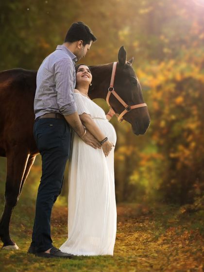 A loving couple shares a glance during their outdoor maternity photoshoot. The warm sunlight and the presence of the horse create a romantic and unforgettable memory before their baby arrives.