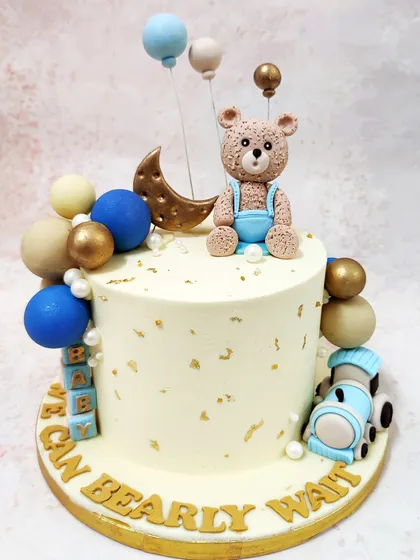 Our Teddy Theme Celestial Cake is a dreamy creation, with a bear sitting among stars, a crescent moon, and a cascade of blue and gold spheres.
